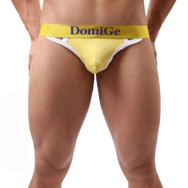 Model wearing DomiGe T-back thong — logo waistband front angle Yellow