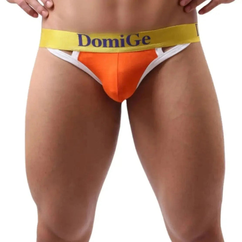Model wearing DomiGe T-back thong — logo waistband front angle orange