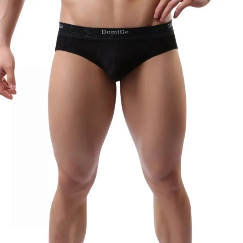 Model wearing DomiGe bamboo briefs mid-rise — signature waistband front angle Black