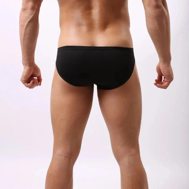 Model wearing DomiGe modal low-rise briefs — embossed waistband back angle Black