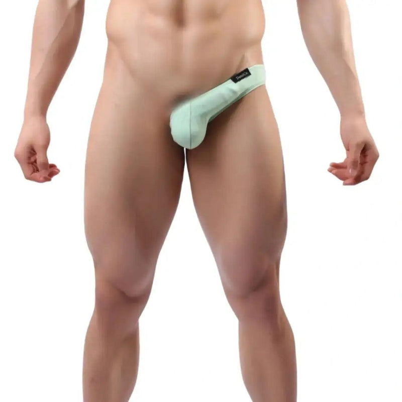 Model wearing DomiGe strappy cotton thong — side straps bold design front angle Bright Green
