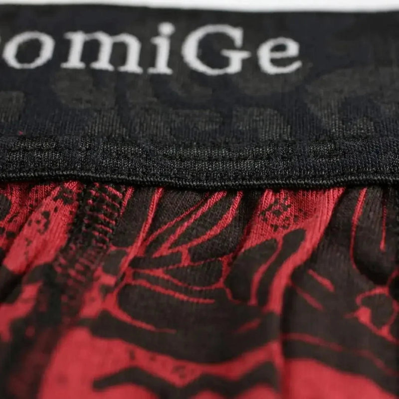 Close-up of DomiGe 3.5cm black waistband with dark floral pattern and woven white DomiGe logo on red print bamboo boxer briefs	