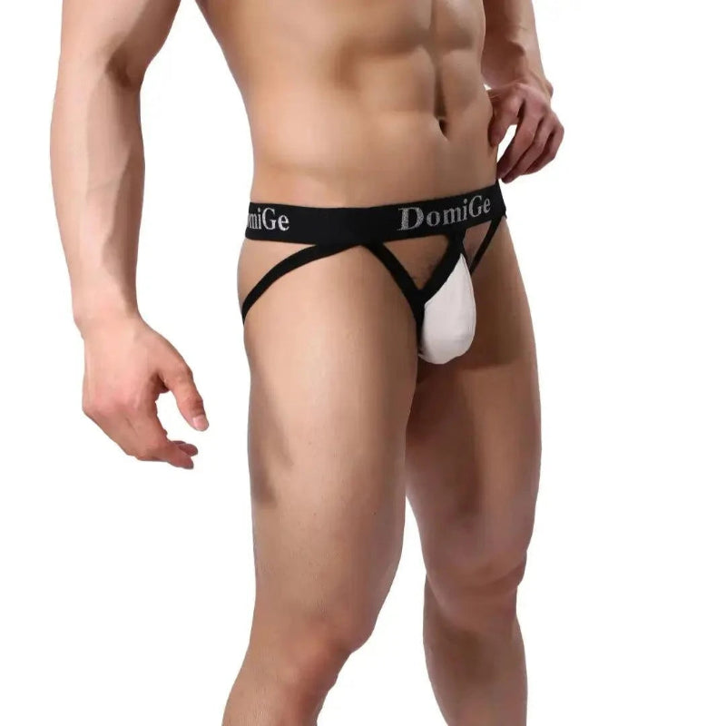 DomiGe cotton lycra jockstrap in beige — model side view showing W-shape back and silver logo waistband	