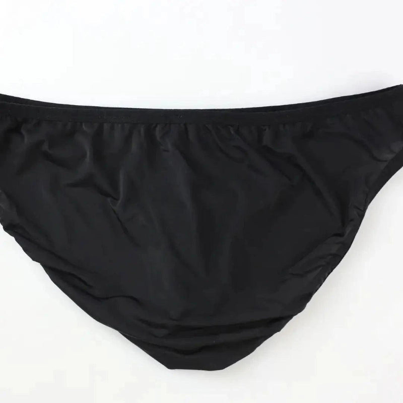 DomiGe elephant cock sock briefs in black — flat lay side view showing contoured pouch and waistband	