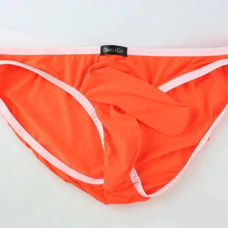 DomiGe elephant cock sock briefs in orange — flat lay front view showing elephant trunk pouch design	