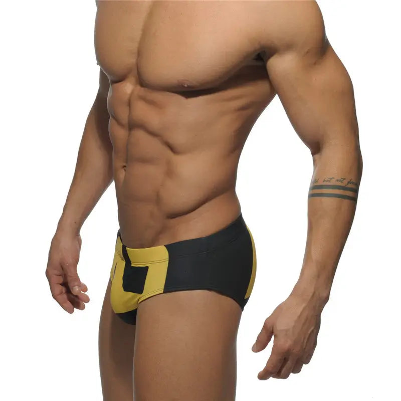 DomiGe fashion swim briefs in black — model side view	