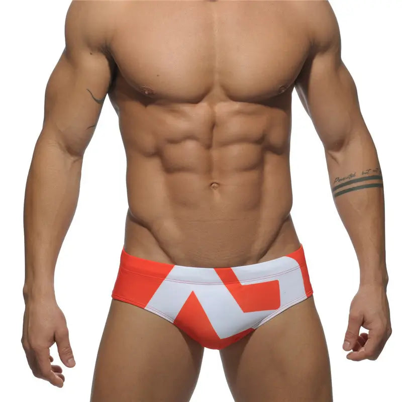 DomiGe fashion swim briefs in orange — model front view	