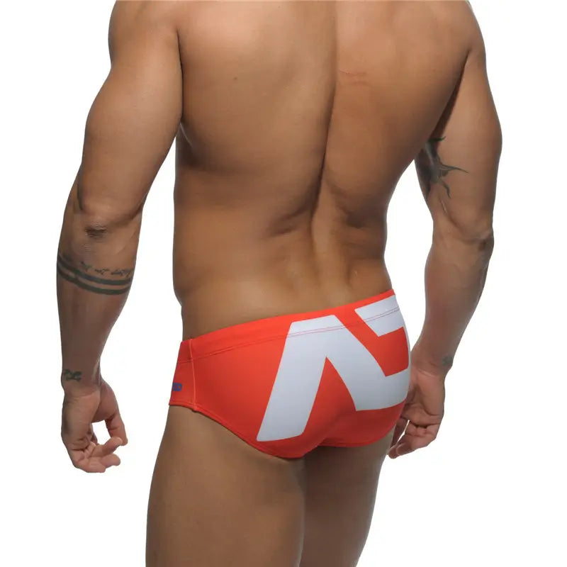 DomiGe fashion swim briefs in orange — model rear view	