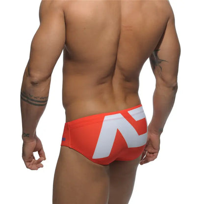 DomiGe fashion swim briefs in orange — model rear view	