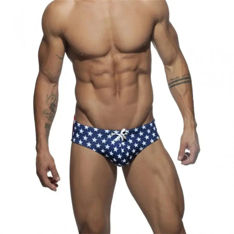DomiGe flag print swim briefs in blue — model front view	