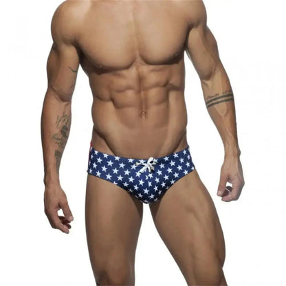 DomiGe flag print swim briefs in blue — model front view	