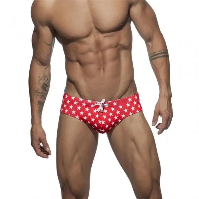 DomiGe flag print swim briefs in red — model front view	