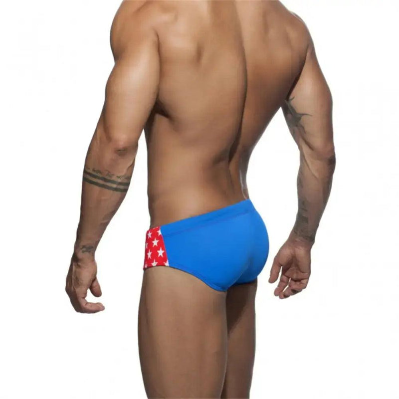 DomiGe flag print swim briefs in red — model rear view	