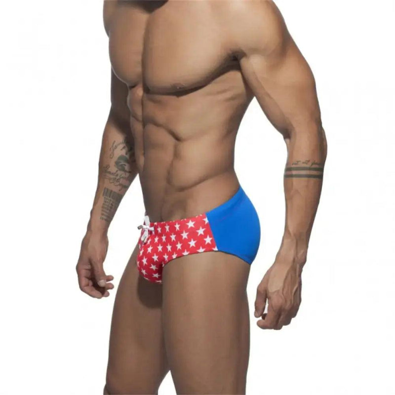 DomiGe flag print swim briefs in red — model side view	