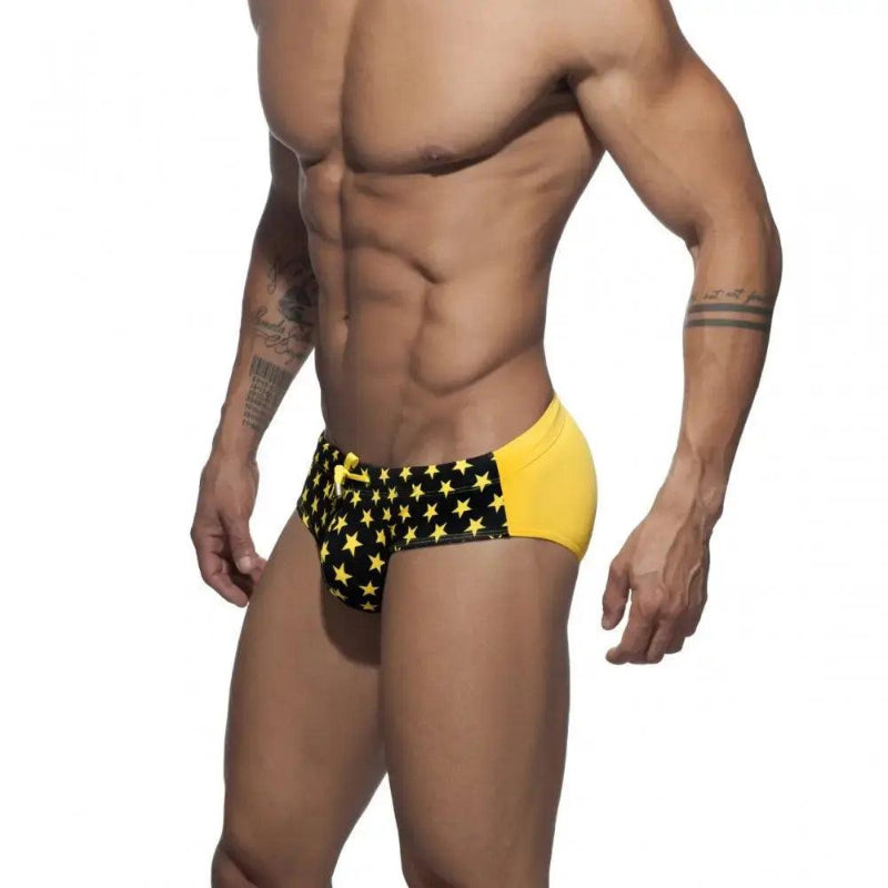 DomiGe flag print swim briefs in yellow — model side view	