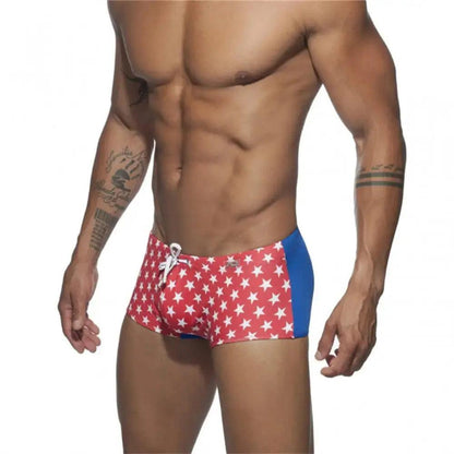 DomiGe men's flag print swim trunks in red — model side view showing low-rise fit and quick-dry fabric	