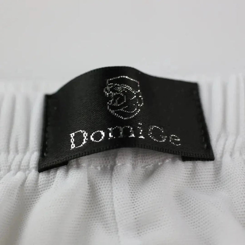 Close-up of DomiGe logo on Comfort Flex Waistband — white modal mesh boxer briefs with adaptive fit	