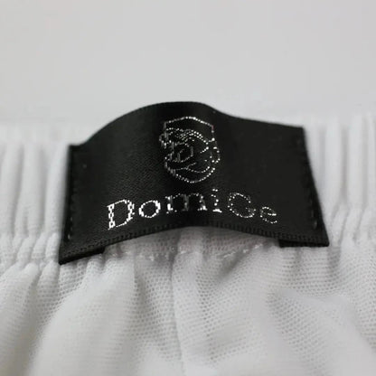 Close-up of DomiGe logo on Comfort Flex Waistband — white modal mesh boxer briefs with adaptive fit	